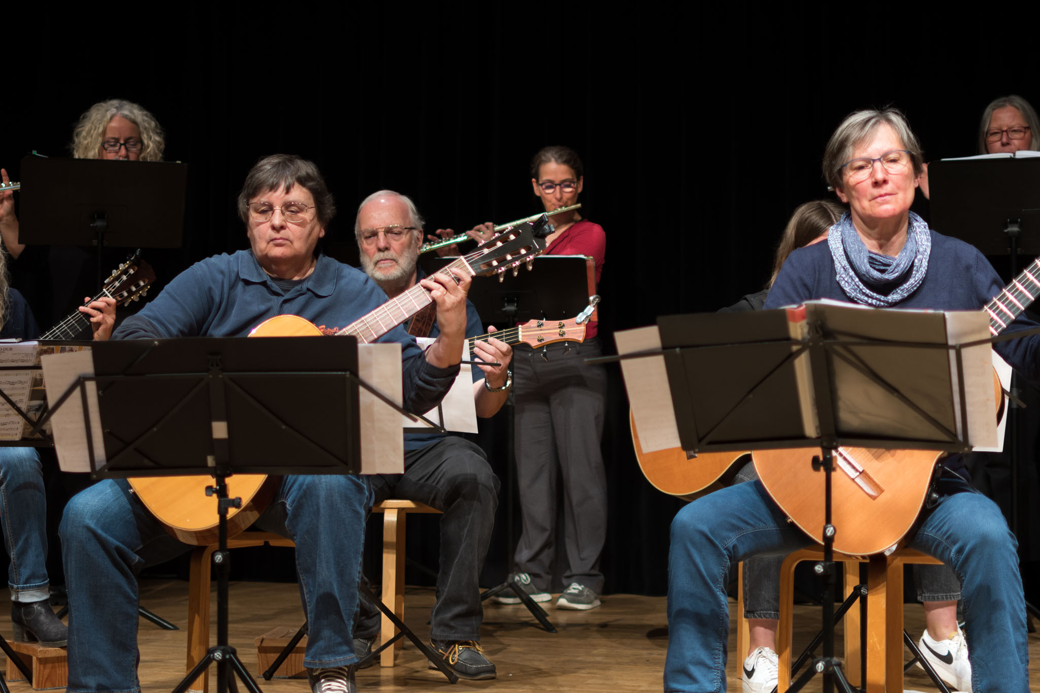 Maria spielt Querflöte zwischen Mitgliedern des Ensembles Saitensprünge