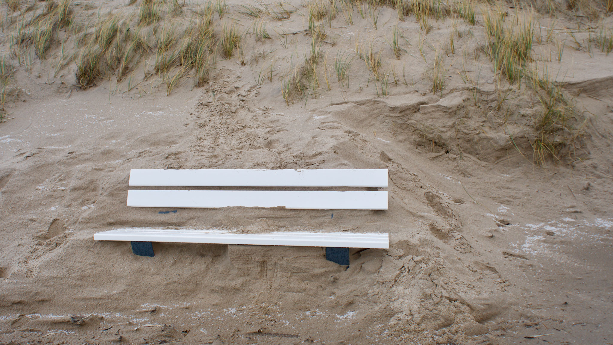 mit Sand zugewehte Bank an einer Düne auf Sylt