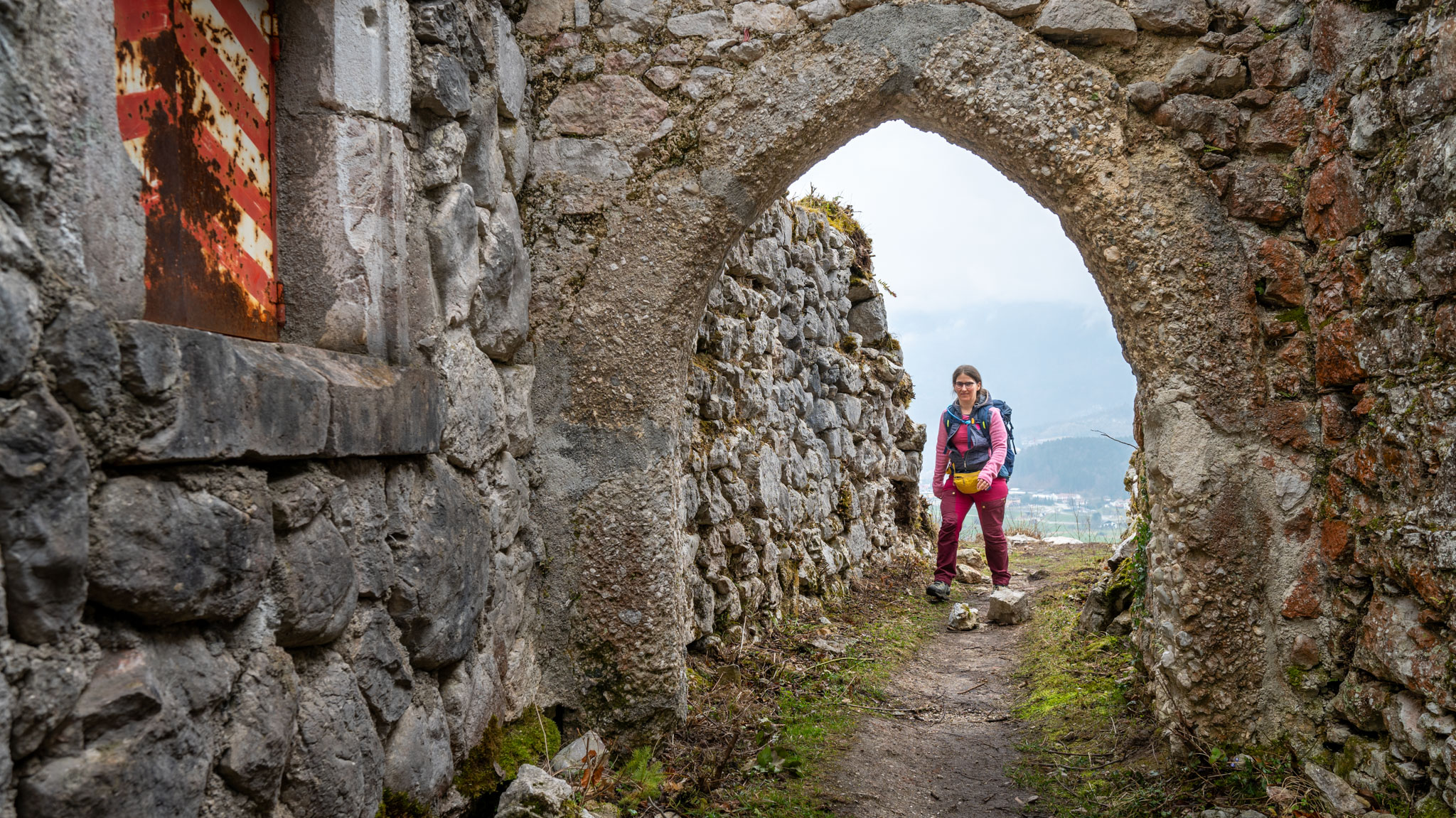Maria geht durch Tor der Ruine Wildenstein oberhalb von Bad Ischl