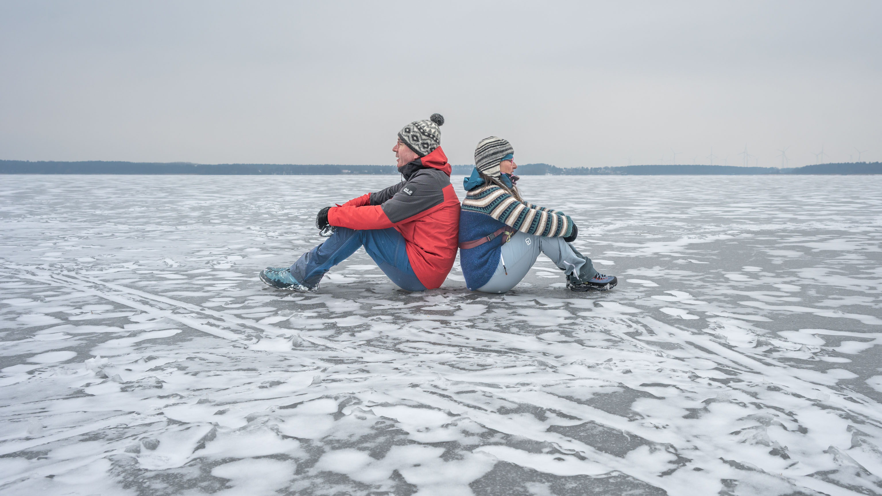 wir beide sitzen Rücken an Rücken auf dem zugefrorenen Plauer See