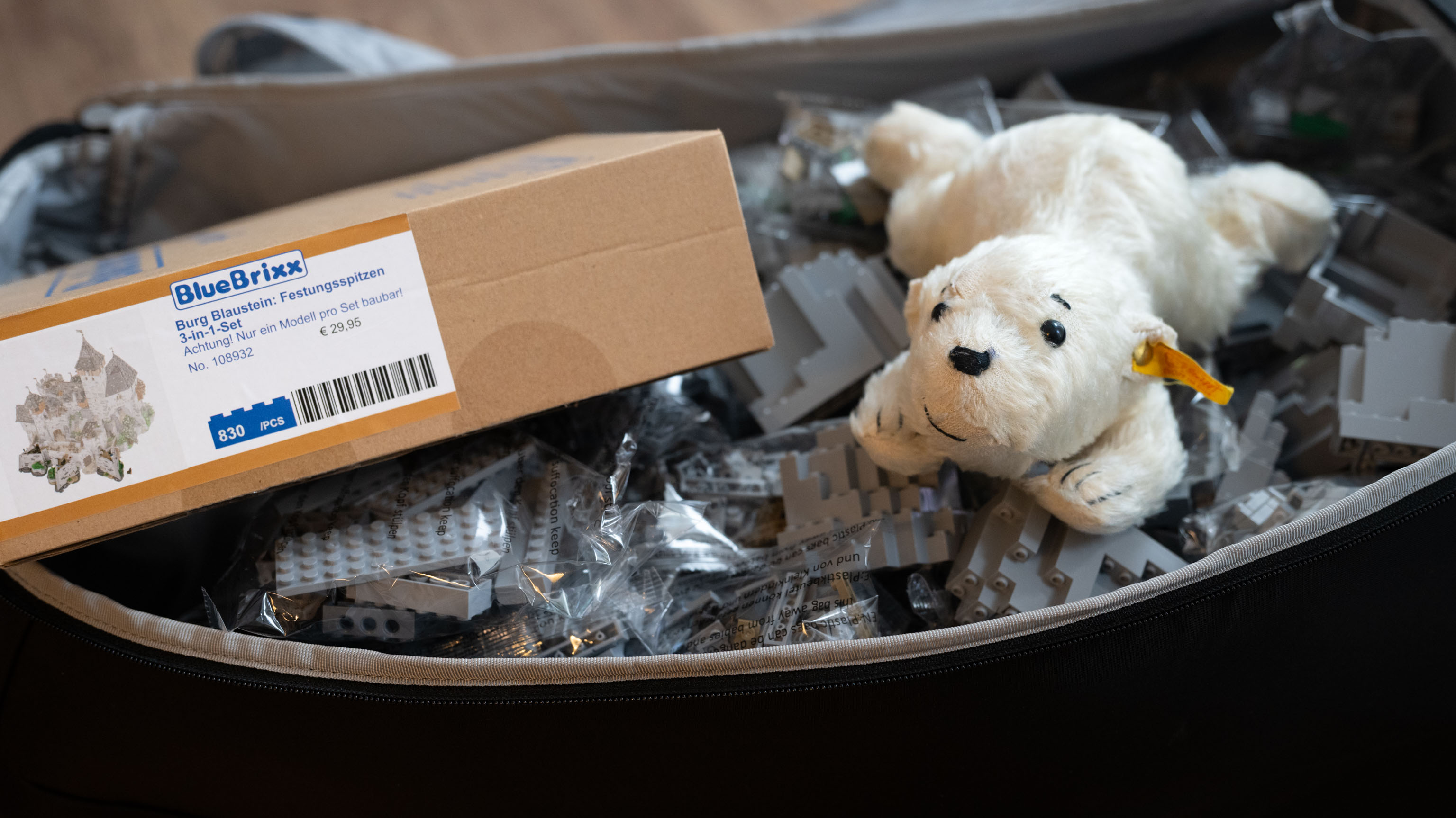 Lars in Marias Koffer, der nahezu komplett mit Legosteinen gefüllt ist